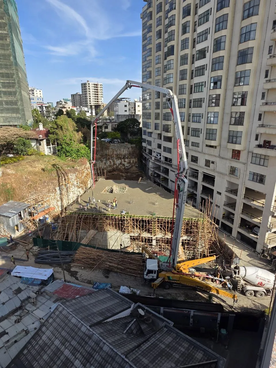 Concrete pump boom working on a multi-story construction site
